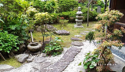 安土城迹总见院茶室庭院一景,苔藓地面、石灯笼与修剪树木构成日式庭园景致