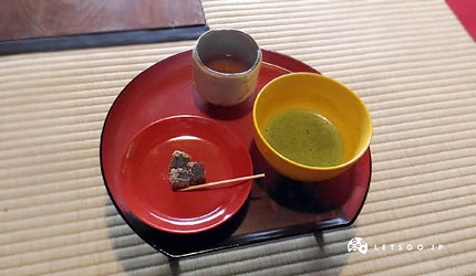 总见院提供的抹茶与和菓子茶点,红色漆器托盘上摆放茶碗与羊羹,室内榻榻米环境