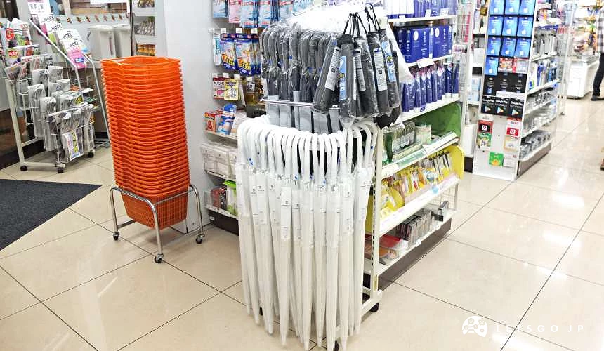 日本便利商店入口旁陳列多把透明雨傘與雨具架供臨時購買