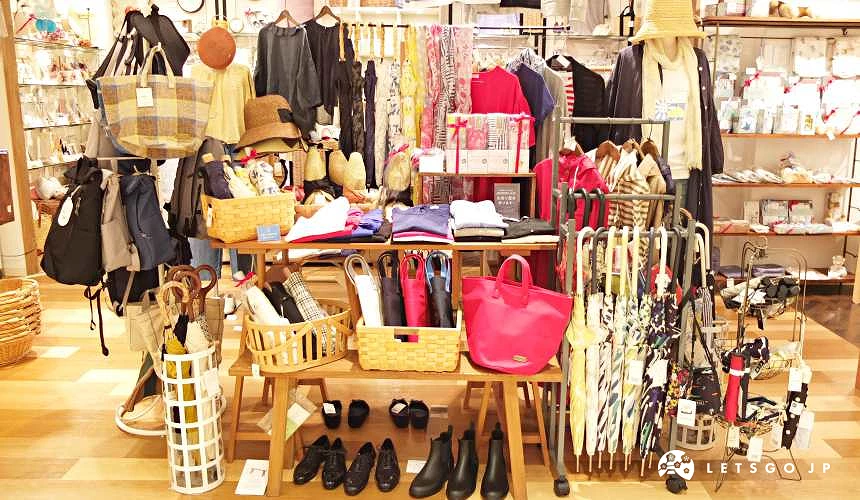 服飾雜貨店內展示多款雨傘與包包配件擺放於木質陳列架上