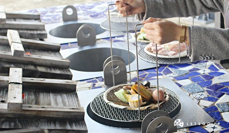 顧客將食材放入地獄蒸釜網架上方進行蒸煮,桌面為藍色馬賽克磚
