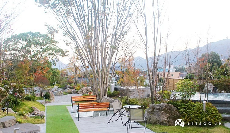 綠意盎然的庭園,設有木椅和造景,氣氛寧靜優雅