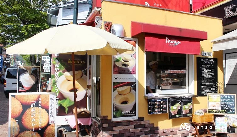 Paomu 甜点店外观,鲜黄外墙与红色遮雨棚,门口有轻井泽布丁与咖哩面包的海报招牌