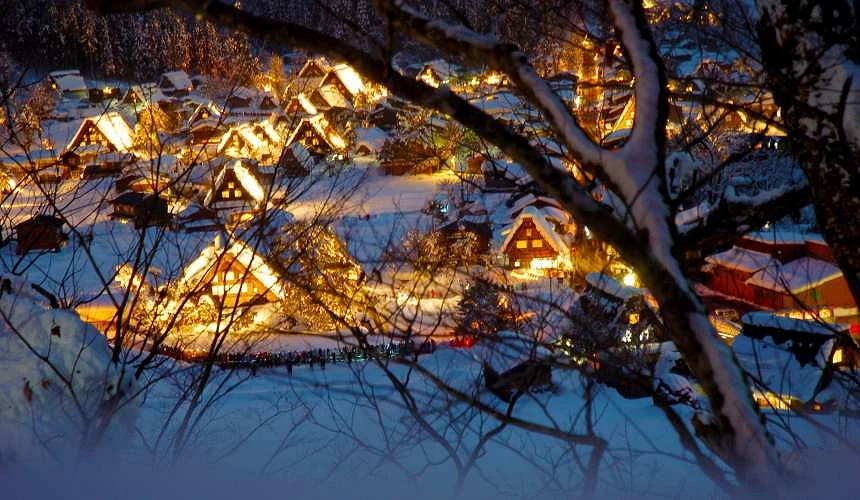 白川乡合掌村点灯,从树林间远眺点灯全景,展现了村落被雪包围的梦幻氛围