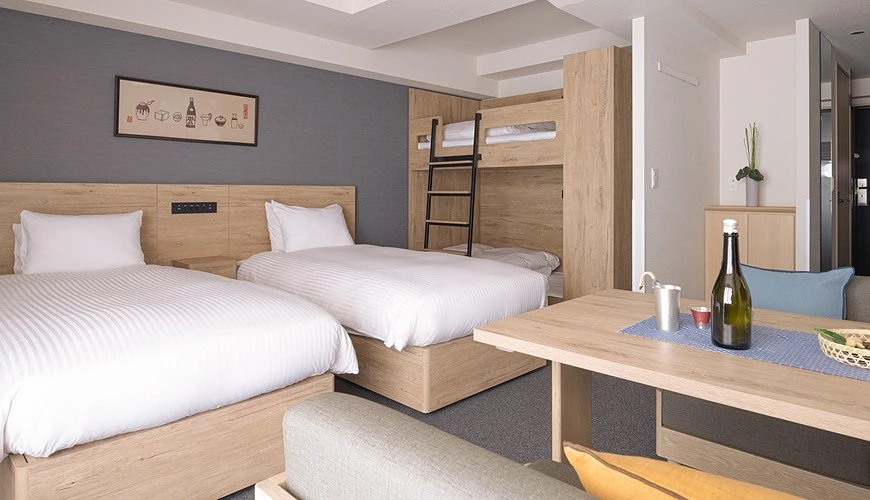 MIMARU 飯店的西式客房配置兩張單人床與上下舖床,搭配木質家具與簡約裝潢,展現寬敞舒適的親子與多人入住空間