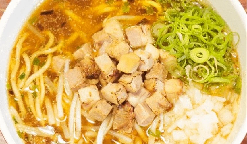 俯瞰一碗日式拉麵裡面有麵及碎肉丁及蔥花丁