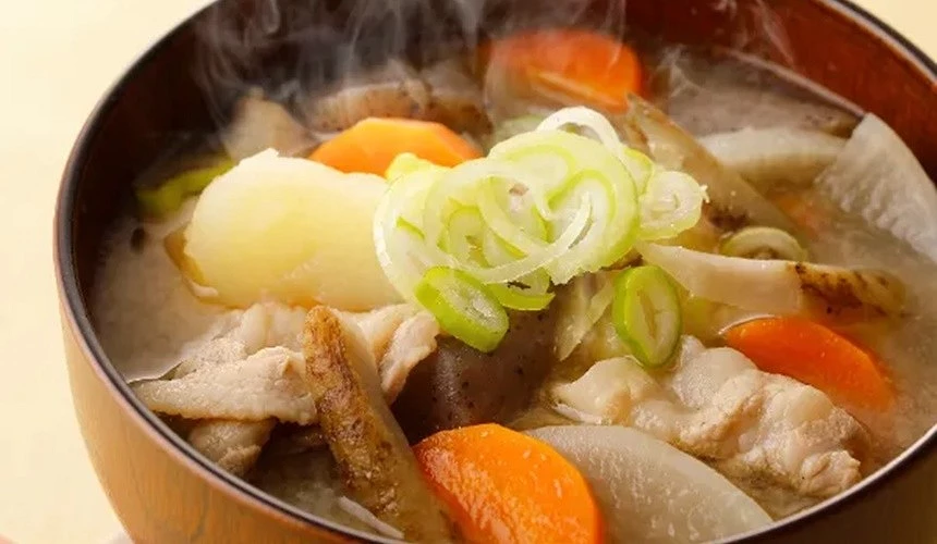 一碗配料滿滿的豬肉味增湯上面擺放少許青蔥