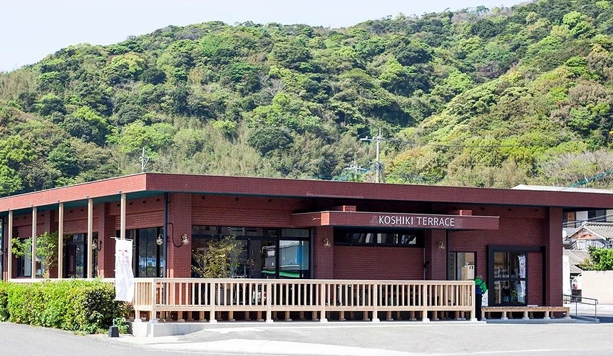 一間深咖啡色的餐廳外觀外面門口左邊有白色欄杆圍起