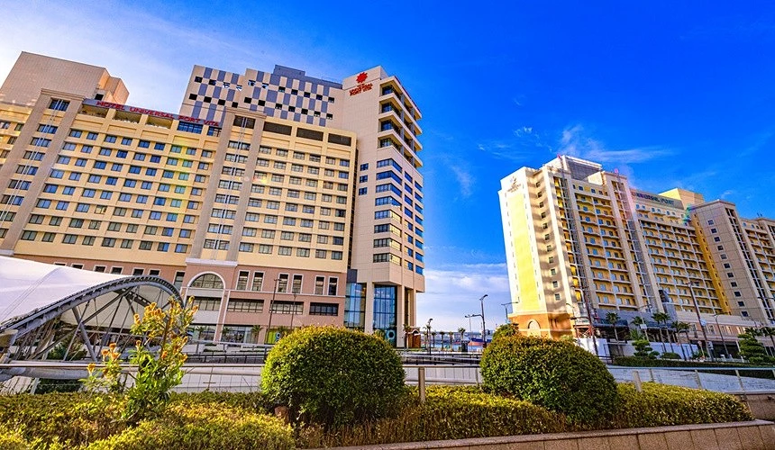 位于大阪环球影城附近的饭店建筑外观,设计色彩鲜明,与蓝天白云相映成趣,展现休闲度假氛围