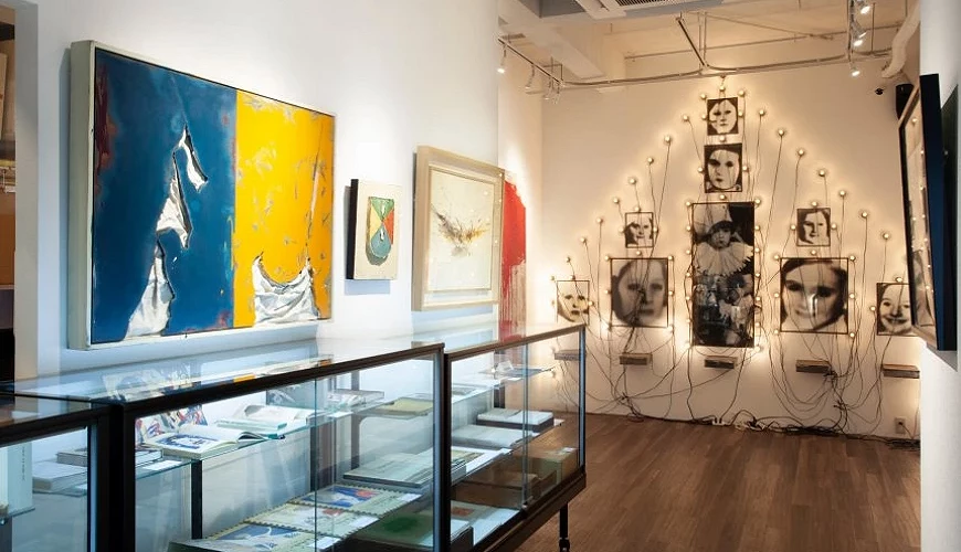 左邊牆上掛著畫,下方有玻璃櫃,正前方牆面擺放藝術作品