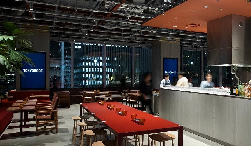 TOKYO NODE 室內酒吧餐廳空間,紅色桌面與高腳椅座位,窗外為東京夜景高樓大廈