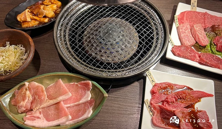 桌上有圓形的烤爐與各種肉片及拼盤