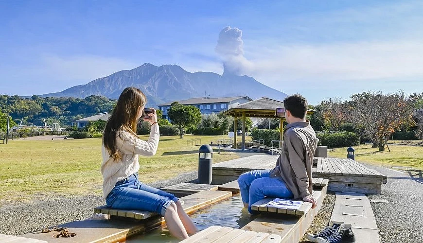 泡足湯的遊客正在眺望櫻島火山