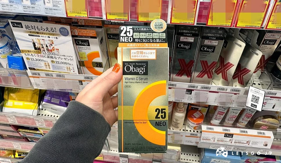 一位女性的手拿着一盒金色上面印有英文Obagi及数字25及一个橘色大大的英文字母C字样的纸盒商品站在商品架