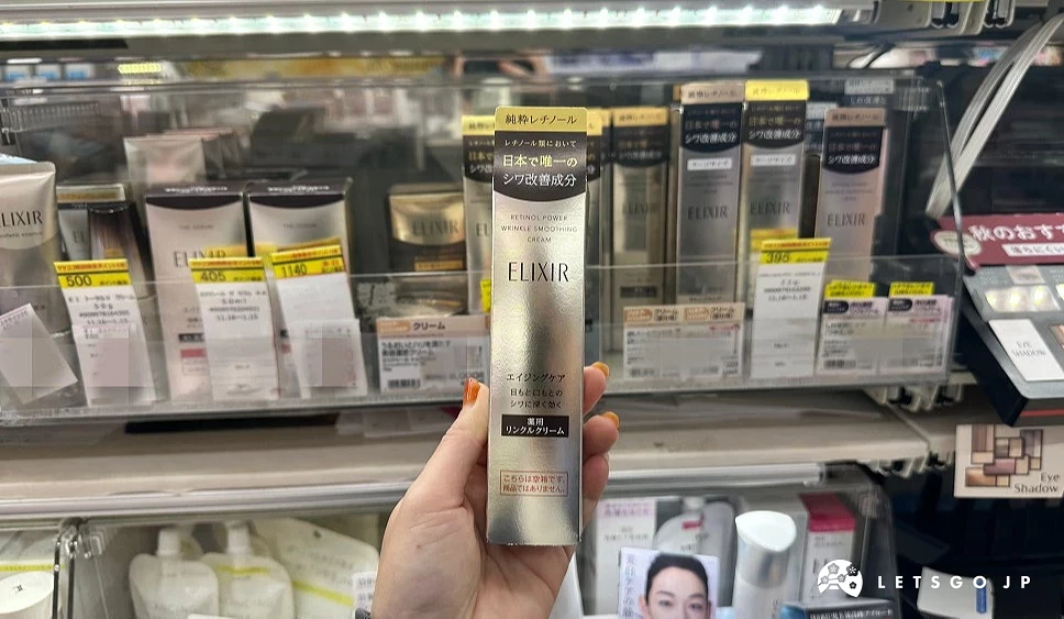 一位女性的手拿着一条金色包装上面印有ELIXIR字样的长型纸盒站在商品架前