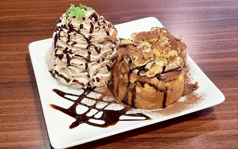 白色盤子上有鬆餅和奶油，搭配巧克力醬裝飾