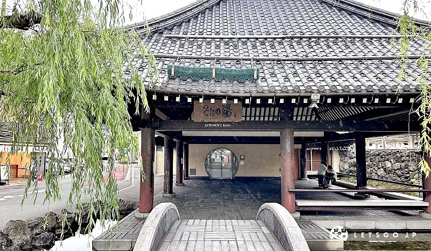 一座圆弧形石桥走进黑色屋顶的日式庭园的城崎温泉七大外汤里汤外观