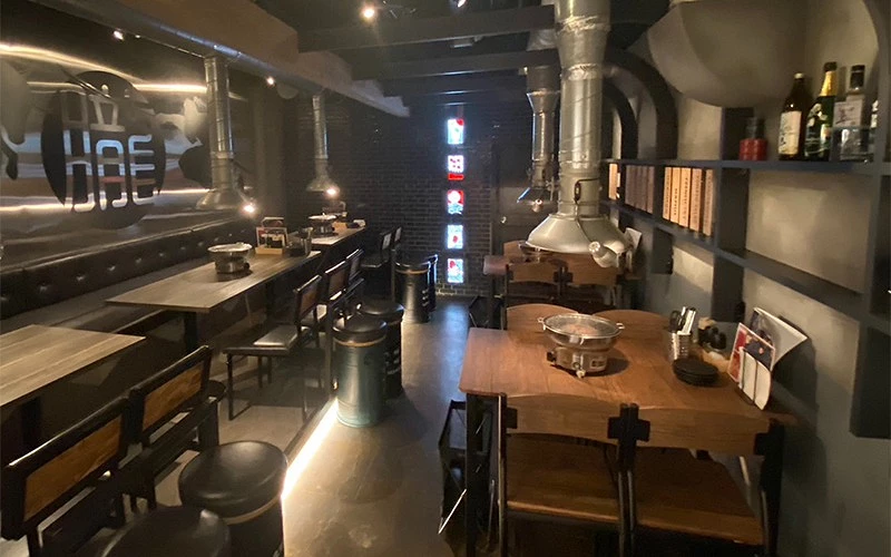 燒肉店內有多張木桌配抽油煙機