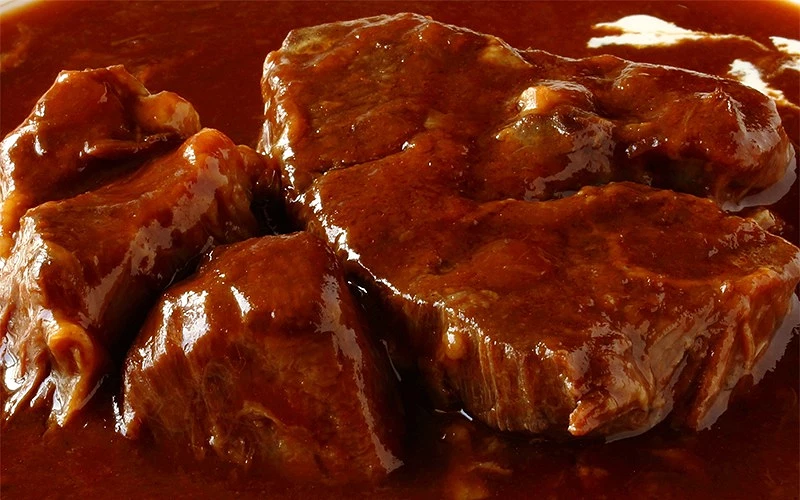 牛肉塊呈焦糖色澤，散發油亮光澤