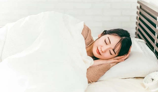 一位女子在白色的被窩中安詳入睡