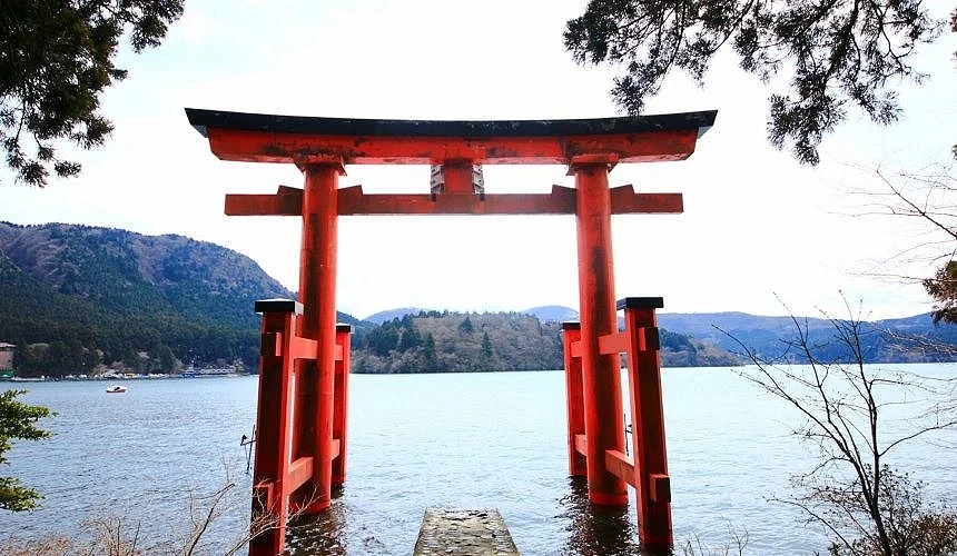 湖中有一個紅色鳥居,湖後方有山脈