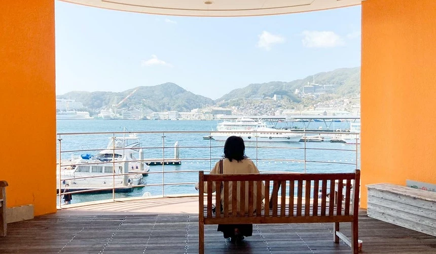 一個人坐在椅子上,前方是海港