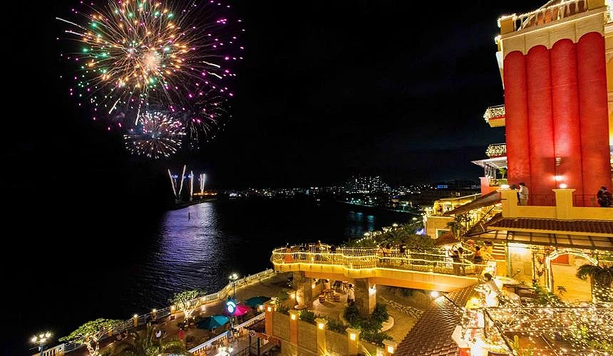 夜晚的建築物與海上施放的煙火