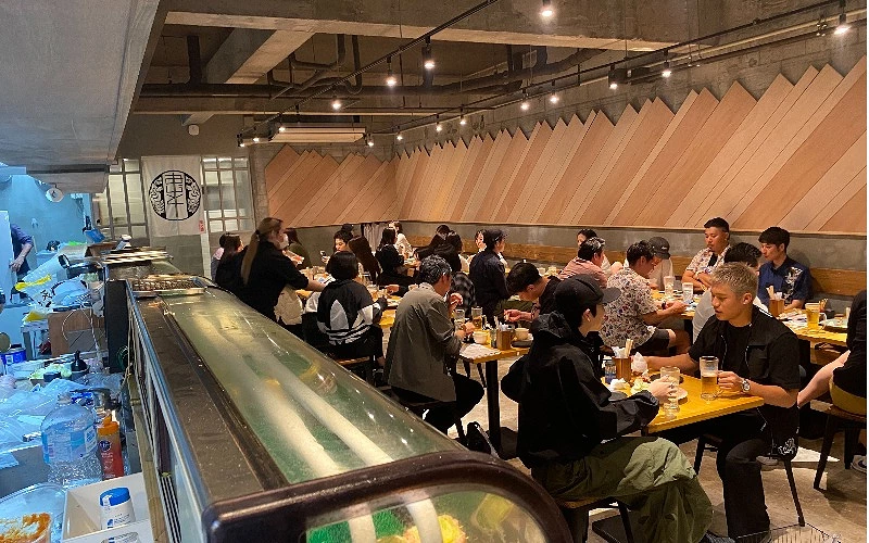餐廳內多組客人坐滿用餐，桌上擺有飲料與餐點