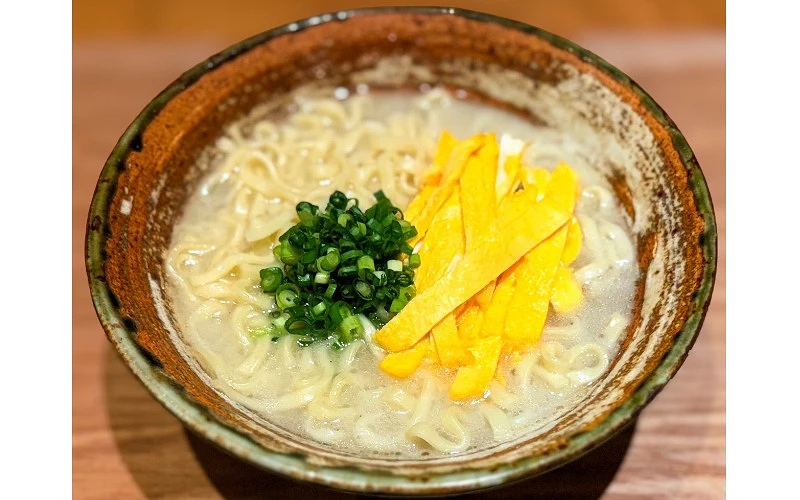碗中盛有麵條，配料包括青蔥與蛋絲