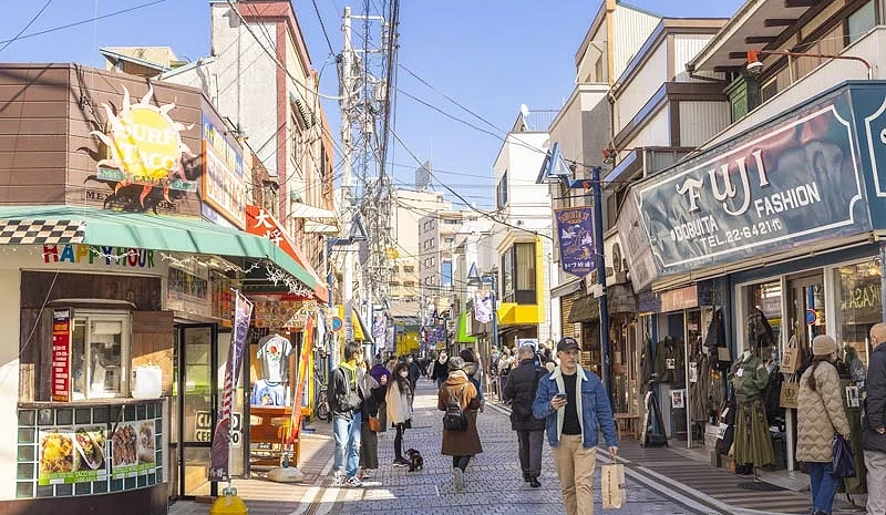 两侧有商店,中间是一条商店街,街上有行人在行走。