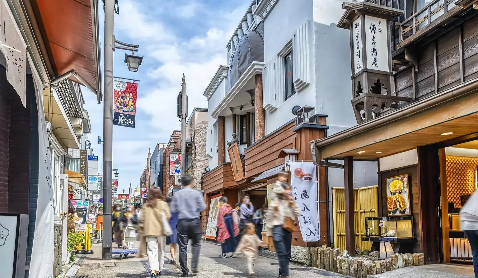 左右两侧有许多商店,中间是人行步道,有行人在行走