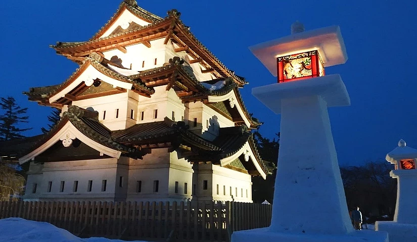 夜間拍攝的照片,左邊是打著燈的城,右邊是被雪覆蓋的燈籠