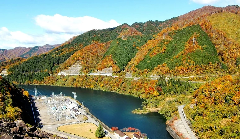 福井县九头龙湖秋季景观,湖面映照周围枫红与黄叶,群山层叠展现壮丽秋色
