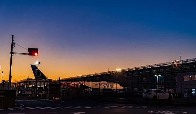 夕阳下的成田国际机场停机坪与航厦建筑,天空渐层色彩映照出宁静氛围