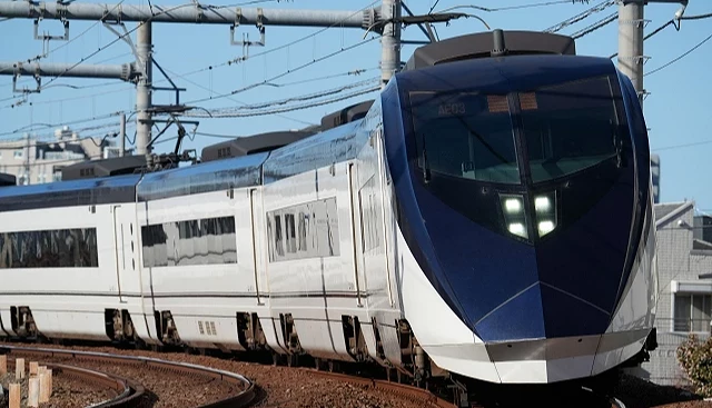 京成電鐵 Skyliner 特急列車行駛在彎道上,藍白配色車身是成田機場最快速往返東京市區的電車