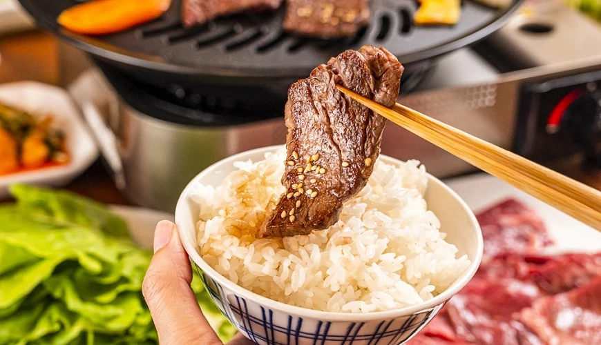 筷子夹取烧肉,搭配白饭