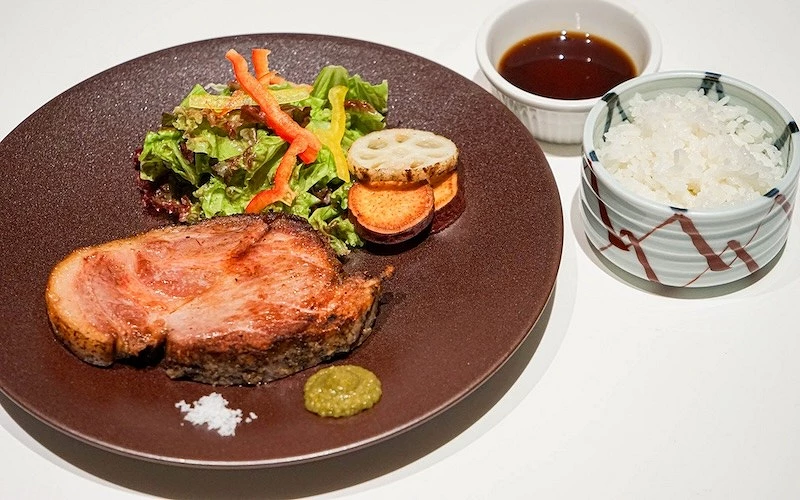 附有沙拉、沾醬和白飯的烤豬肉定食
