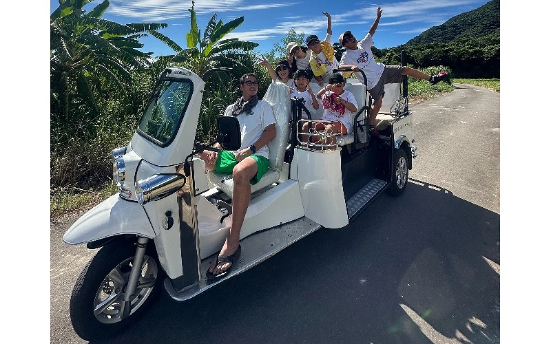 一群人乘坐在白色巨型三輪車