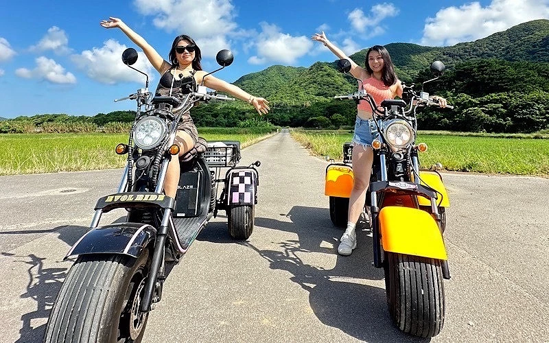 兩位女性各乘坐一台三輪車