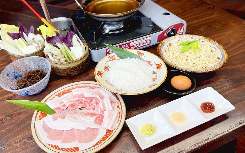 沖繩阿古豬涮涮鍋套餐，搭配新鮮蔬菜、白飯、沖繩麵及醬料的日式火鍋料理