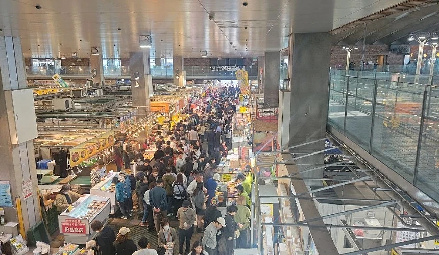 室內市場人潮擁擠,攤位販售各式海鮮與料理