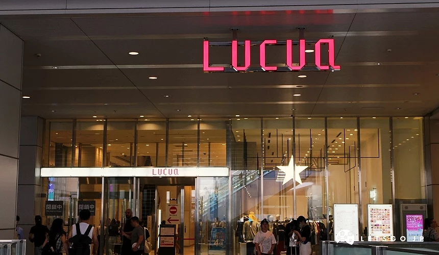 商場入口上方懸掛「LUCUA」紅色發光招牌,玻璃門前有人進出