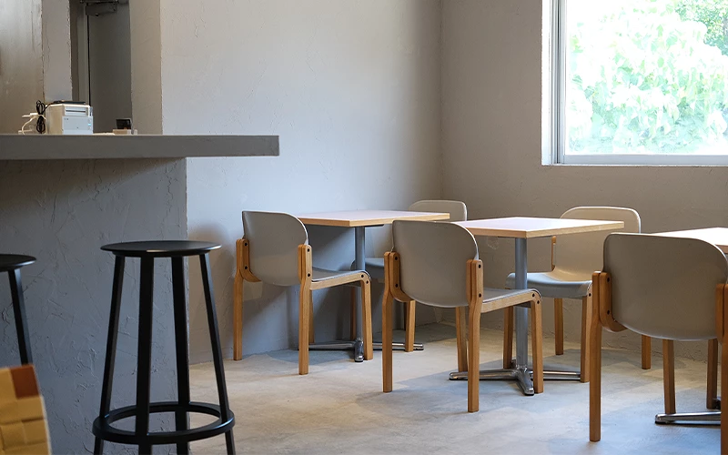 灰色牆面與木製桌椅構成的簡約咖啡廳內部空間