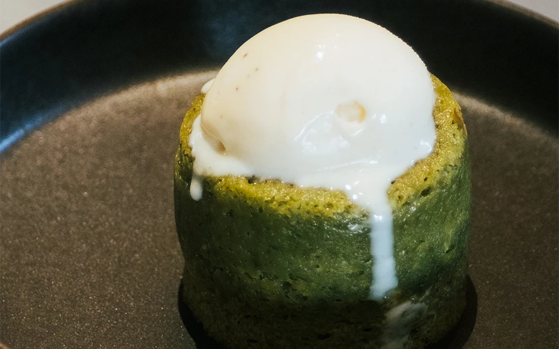 抹茶熔岩蛋糕上放一球香草冰淇淋並微微融化