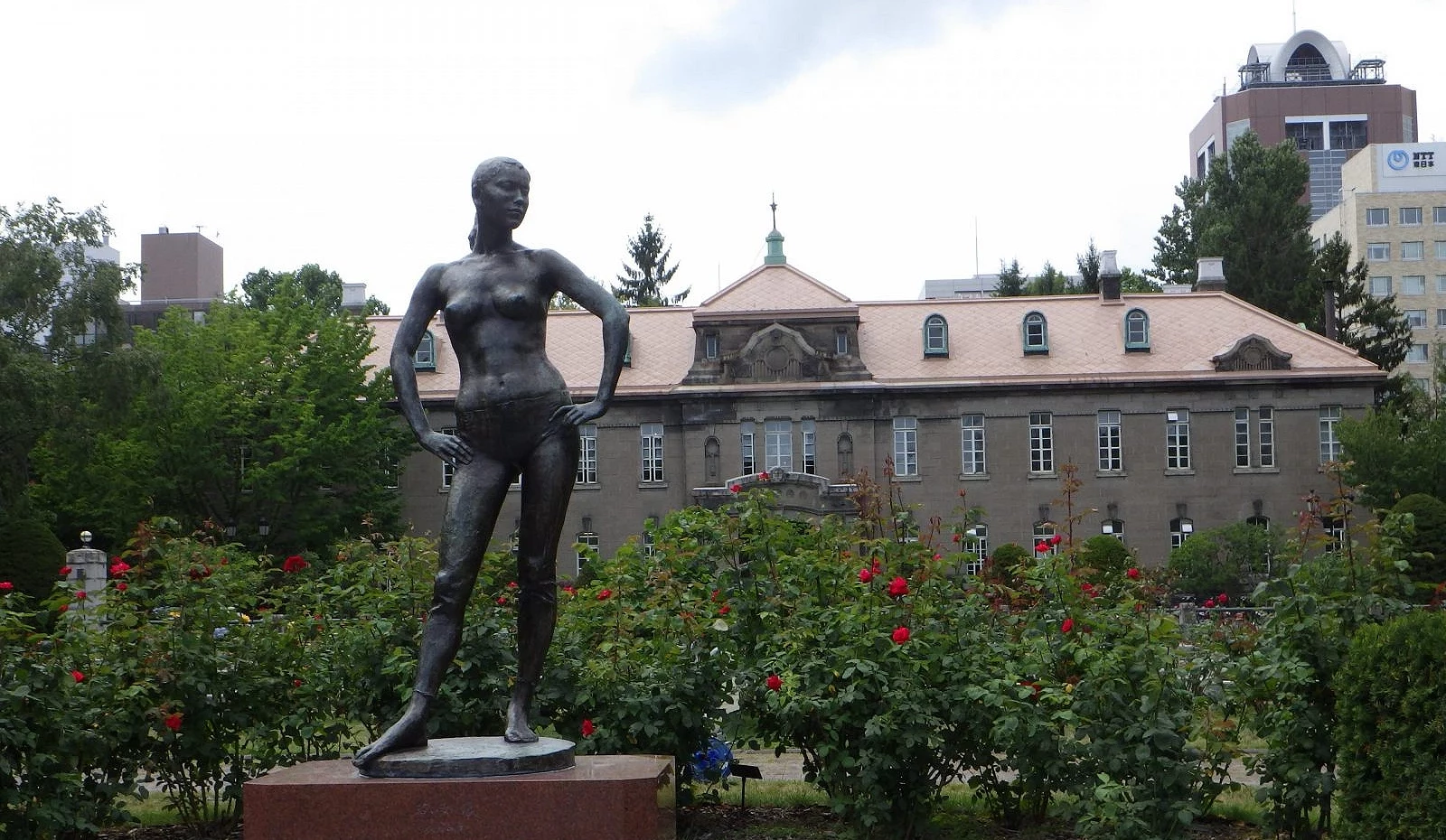 札幌大通公园西12丁目的Sunken Garden区,前景为佐藤忠良雕塑的年轻女子像,背景是札幌市资料馆与盛开的玫瑰花园