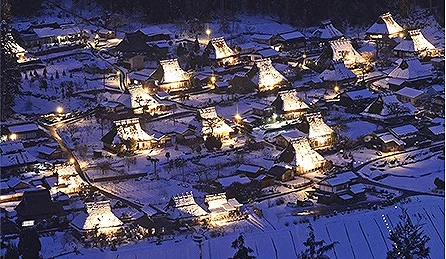 被白雪覆蓋的美山茅葺之里從高處俯瞰,茅草屋屋頂亮起燈光,整座村落宛如童話般的雪中光之村莊