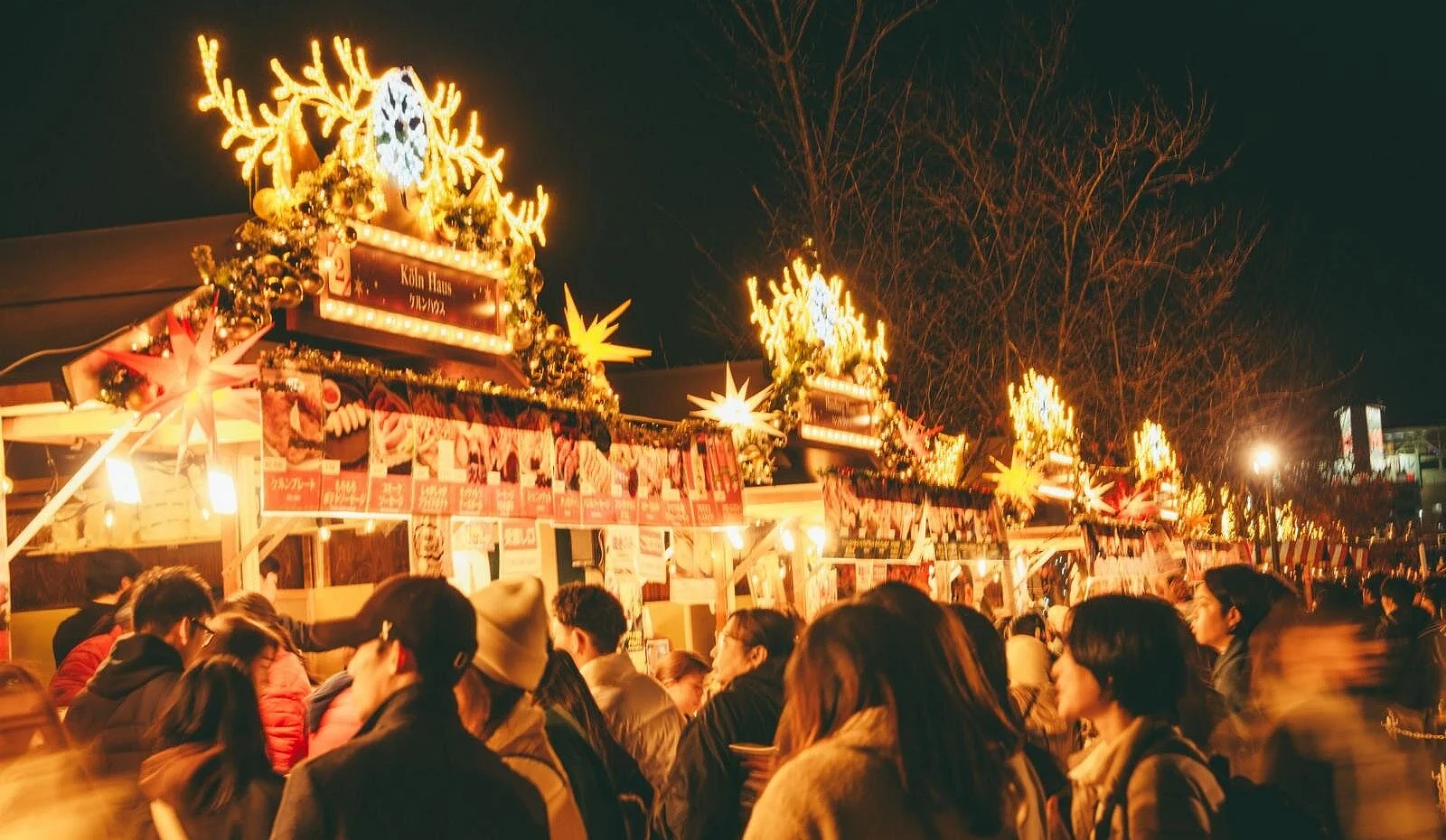 大阪天王寺聖誕市集熱鬧登場,木製攤位裝飾著燈飾與金色星星,販售各式節慶甜點與飲品,人潮絡繹不絕