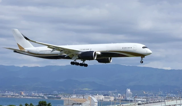 飛機在關西國際機場上空降落,背景可見大阪灣與城市景觀