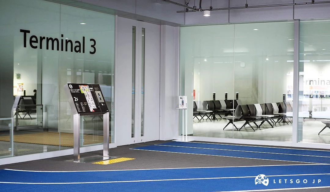 成田第三航厦入口与候机区,地面有蓝色导引线设计,玻璃墙后可见黑白座椅整齐排列的候机空间
