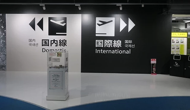 成田机场第三航厦内部墙面标示,左侧为「国内线 Domestic」,右侧为「国际线 International」,黑白对比设计让旅客清楚辨识登机方向